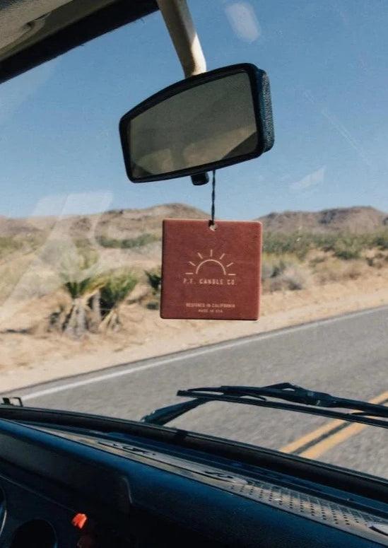 Square Car Freshener hanging from a rearview mirror in a car